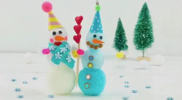Zwei süße Schneemänner, perfekt zum Basteln Weihnachten Kinder. Sie tragen bunte Mützen und Schals, umgeben von kleinen Weihnachtsbäumen.