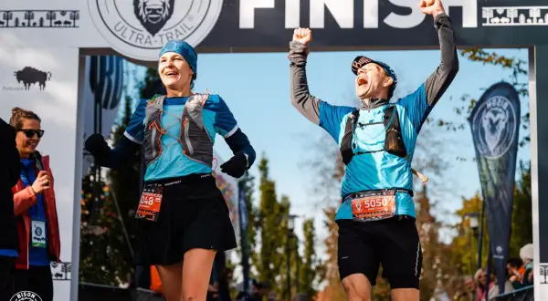 Dwaj biegacze z radością przekraczają linię mety Bison Ultra-Trail Supraśl.