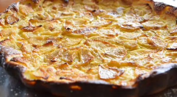 Une flognarde aux pommes dorée et appétissante, saupoudrée de sucre glace. Un délice fait maison.