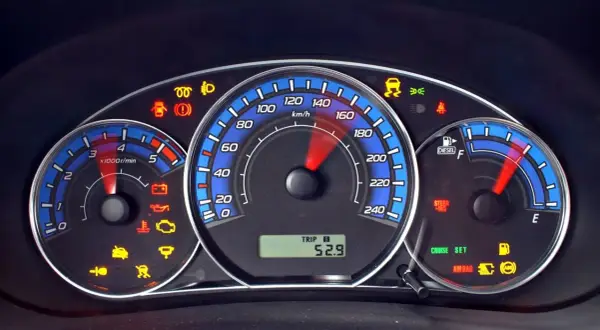 Deska rozdzielcza Ford Kuga z wieloma kontrolkami, w tym ABS, poduszka powietrzna i ostrzeżenie o niskim poziomie paliwa.