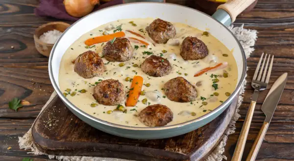 Herzhafte Frikadellen in cremiger Soße mit Erbsen und Karotten, ein köstliches Wikingertopf Rezept.