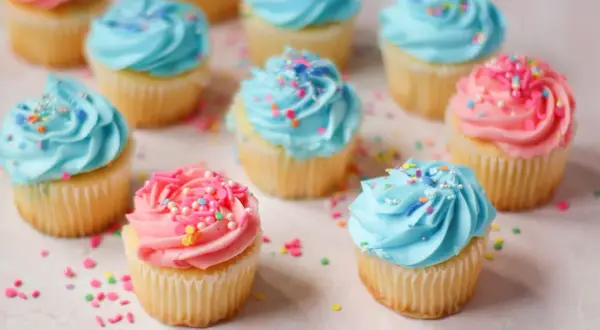 Söta cupcakes med blå och rosa frosting, strössel. Perfekt för ett gender reveal tårta recept.