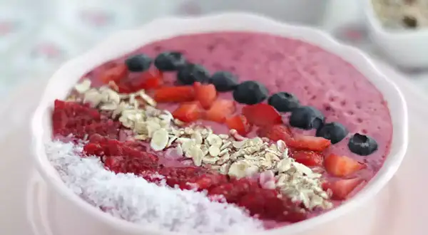 En rosa smoothie bowl med hallon, blåbär, jordgubbar, kokosflingor och granola. En perfekt start på dagen!