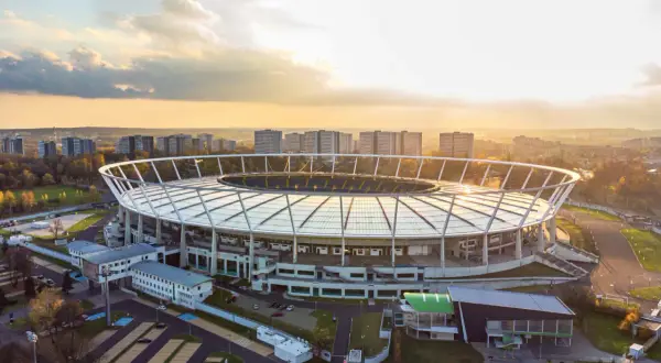 Stadion Śląski w Chorzowie o zachodzie słońca. Obiekt, który gościł niezliczone koncerty, otoczony jest zabudową miejską i zielenią.