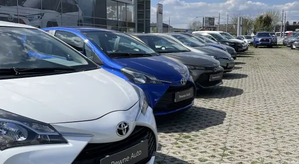 Rząd lśniących, **toyota używane z salonu** czeka na nowych właścicieli. Wśród nich biała, niebieska i grafitowa.