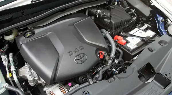 Silnik D-4D w Toyota Avensis T27, z widocznym logo Toyoty i elementami osprzętu, jak akumulator i obudowa filtra powietrza.