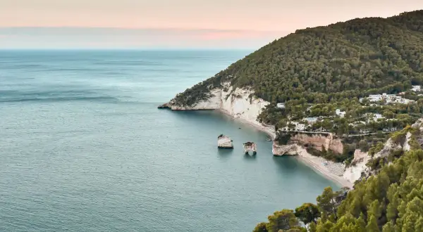 La baia dell'amore, con le sue scogliere bianche e il mare azzurro, incanta sotto un cielo rosa. Un luogo da sogno.