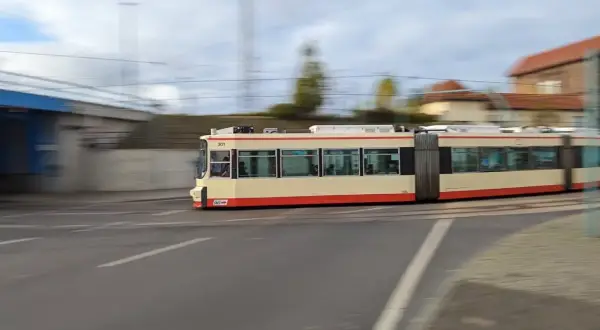 Ein langer, gelber und roter Straßenbahnzug fährt durch Wrocław. Mit jakdojade wrocław finde ich schnell die nächste Haltestelle.