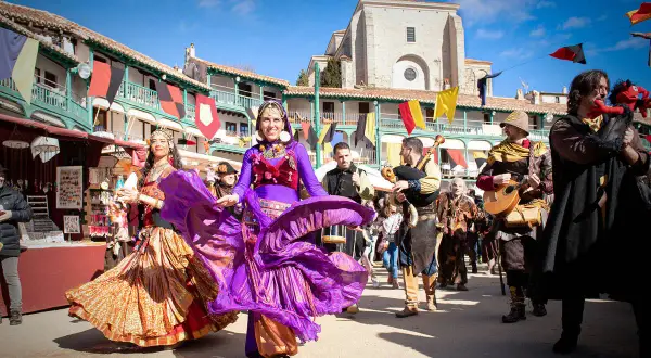 Danza y música en la feria medieval de Madrid. Bailarinas con trajes coloridos y músicos con instrumentos de época animan la celebración.