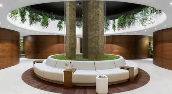 Nowoczesne wnętrze spa z okrągłą sofą, roślinnością i drewnianymi panelami.