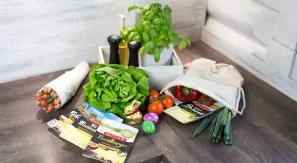Frische Zutaten wie Salat, Tomaten, Paprika und Kräuter, dazu Käse und ein Osterhase – alles da, um Lebensmittelverschwendung zu vermeiden und leckere Mahlzeiten zu zaubern.