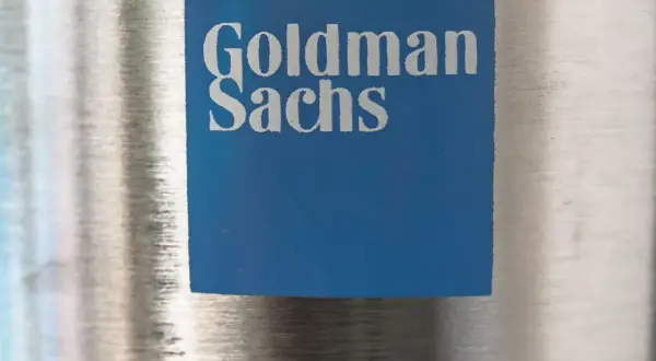 Niebieski kwadrat z logo Goldman Sachs, symbolizujący stabilny wzrost i pewność w świecie finansów.