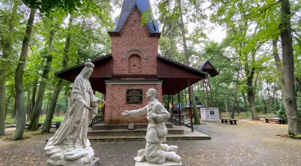 Kapliczka z figurami Matki Bożej i klęczącego mężczyzny. Warto zobaczyć po drodze do Lichenia, piękny las wokół.