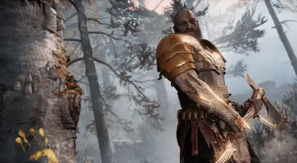 Kratos im neuen Spiel+ von God of War, bereit für neue Abenteuer. Seine goldene Rüstung glänzt im nebligen Wald.