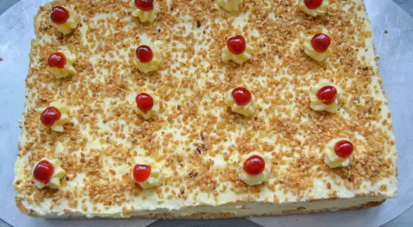 Rechteckiger Kuchen mit Buttercreme, gehackten Nüssen und Kirschen, wie Frankfurter Kranz Schnitten.