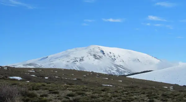 El pico más alto de Almería, cubierto de nieve, se alza majestuoso bajo un cielo azul despejado.