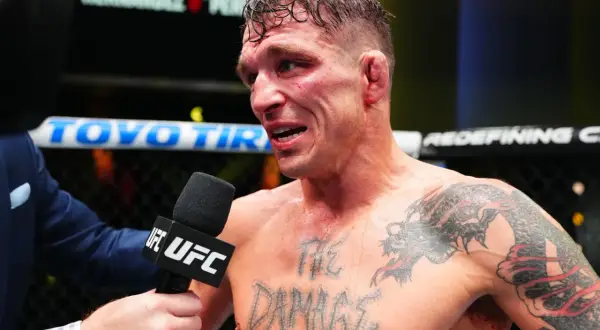 A bloodied fighter, interviewed post-fight, shows the "md" in boxing is the damage taken. His chest tattoo reads "THE DAMAGE".
