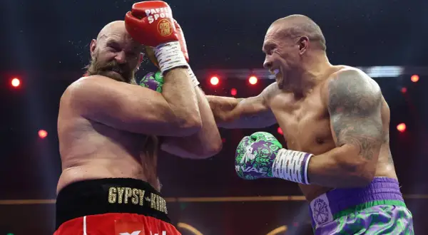 Two boxers clash in the highest weight class in boxing. Sweat flies as one lands a powerful punch, the other defends.