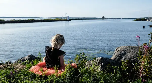 Flicka i tyllkjol vid vattnet nära ett vandrarhem i Mariestad.