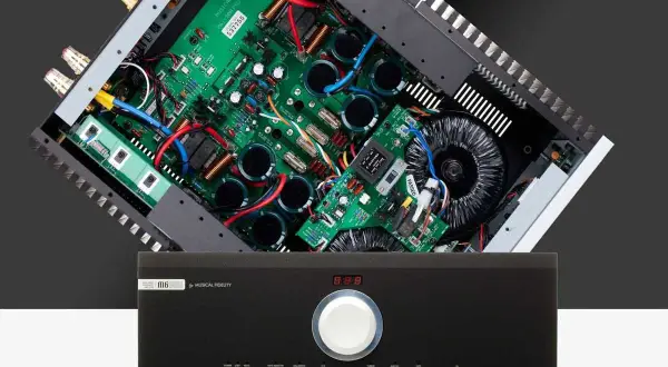 Wnętrze wzmacniacza Musical Fidelity M6 500i z widocznymi kondensatorami i transformatorem.