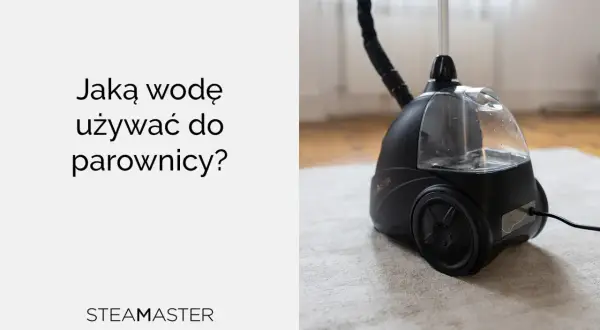 Jaka woda do parownicy? Czarna parownica Steam Master z przezroczystym zbiornikiem na wodę, stojąca na jasnym dywanie.