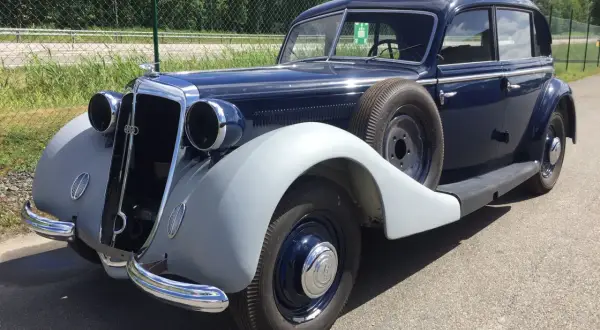 En mörkblå Horsch bil från 1930-talet med reservhjul på sidan.