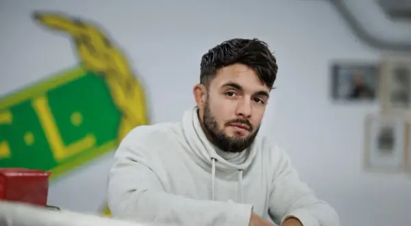 Anthony Yigit, en svensk boxare, blickar mot kameran i en ljus studio.