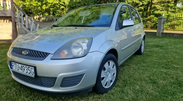 Srebrny Ford Fiesta Mk5 na trawniku, z widocznym numerem rejestracyjnym PTU 4935G.
