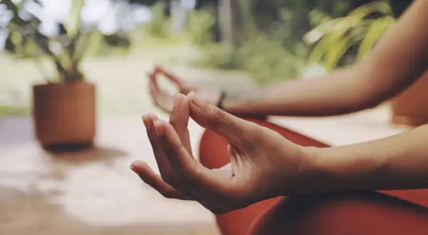 Manos en posición de meditación, con el pulgar e índice unidos, un mudra de energía.