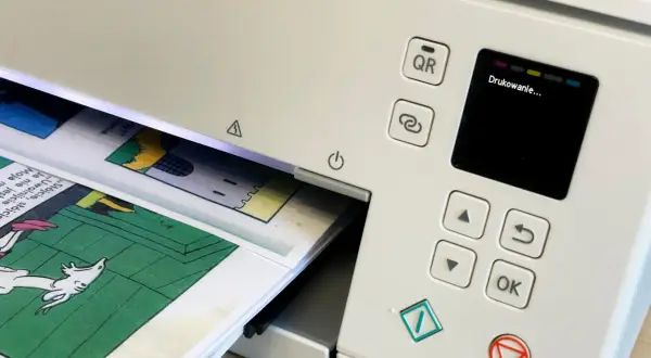 Drukarka drukuje komiks. Chcesz pobrać **adobe acrobat za darmo**? Zeskanuj kod QR lub użyj przycisku "OK".