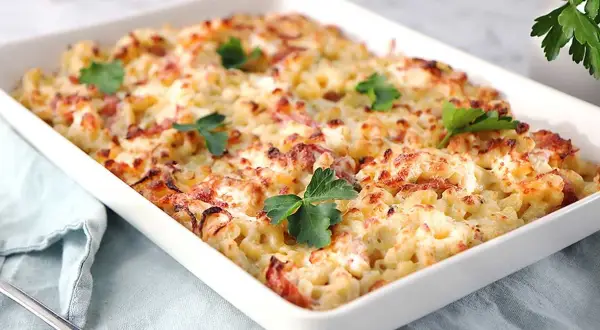 En krämig gratäng med makaroner, ost och bacon, perfekt för ett gott ostsås recept. Garnerad med färsk persilja.