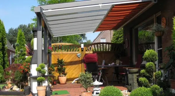 Moderne Terrassenbeschattung Ideen: Eine elegante Pergola mit ausfahrbarem Markisen-Dach schützt die gemütliche Sitzecke im Garten.