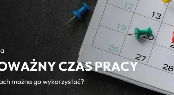 Zbliżenie na kalendarz z kolorowymi pinezkami zaznaczającymi dni.