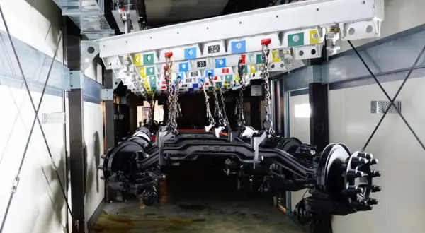 Assali di camion in sospensione pronti per la verniciatura. Il sistema di trasporto aereo è pronto per la verniciatura dei camion.