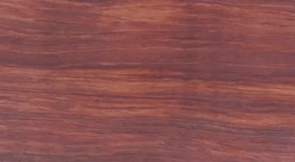 Textura rica y veteada de madera bubinga, con tonos rojizos y marrones que evocan la calidez de la naturaleza.