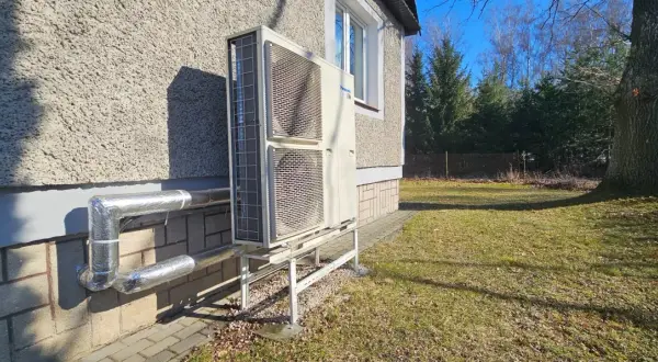 Pompa ciepła Panasonic zamontowana przy nowym domu. Instalacja zasilana dzięki dotacji, zapewnia ekologiczne ogrzewanie.