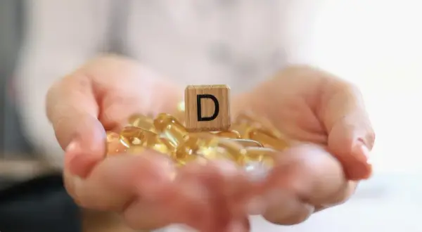 Dłonie trzymają kapsułki z witaminą D3. Jaka dawka dla psa będzie najlepsza?