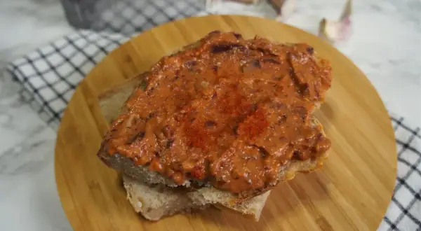Pyszna pasta z czerwonej fasoli na chlebie, posypana papryką. Idealna na szybką przekąskę.