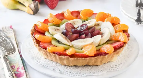 Deliciosa tarta de fruta natural, cubierta con fresas, kiwi, plátano, mandarina y uvas. ¡Un postre fresco y colorido!