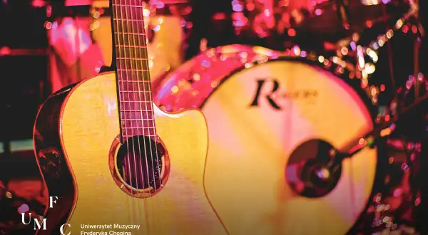 Gitara i bębny na scenie, gotowe do występu. Może to Łukasz Talarek przygotowuje się do koncertu?
