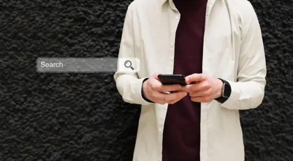 Mężczyzna z telefonem szuka w sieci informacji, jak włączyć Google Discover.