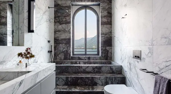 Bagno di lusso con vasca e doccia in muratura, rivestimenti in marmo e vista panoramica. Idee per una doccia in muratura moderna.