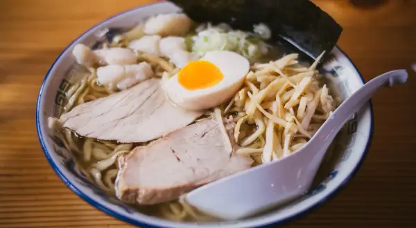 Miseczka ramenu z plastrami mięsa, jajkiem i bambusem. Czy można jeść ramen w ciąży? To danie wygląda apetycznie!