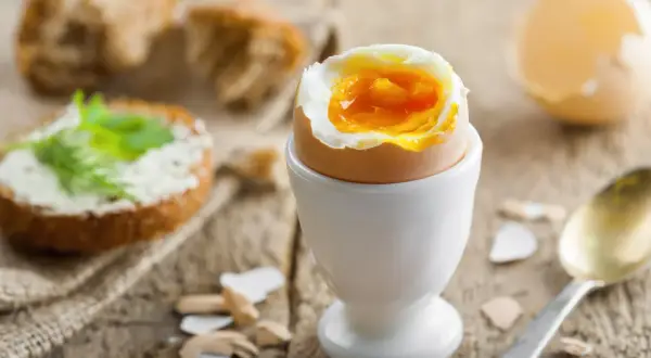 Un huevo duro 8 minutos con la yema líquida, listo para disfrutar con pan tostado y mantequilla.