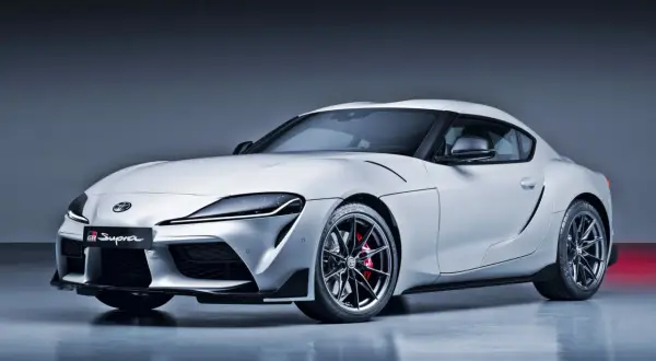 Biała Toyota GR Supra z czerwonymi zaciskami hamulcowymi i czarnymi felgami. Ta marka samochodu na zdjęciu to Toyota.