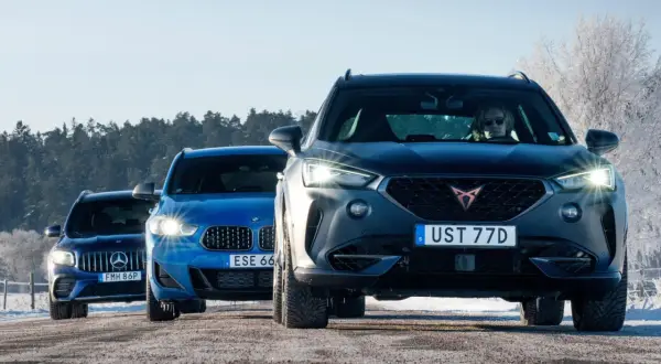 Tre SUV:ar, en mörkgrå Cupra, en blå BMW och en mörkblå Mercedes, kör på en snöig väg. AWD betyder att alla hjulen driver, perfekt för vinterväglag.
