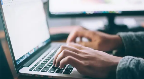 Dłonie piszą na klawiaturze laptopa, korzystając z szybkiego połączenia LTE do pracy zdalnej.