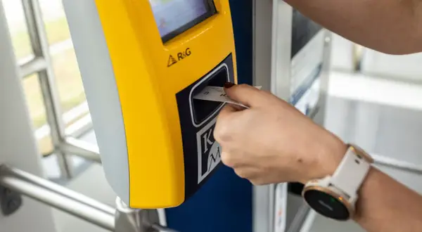 Wkładanie biletu dobowego Kraków do żółtego automatu.