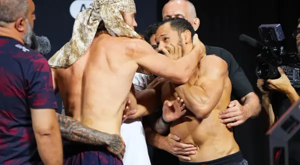 Två MMA-fighters, en med huvudduk, brottas under en vägning. Cody Brundage är en av dem.