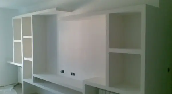 Parete attrezzata fai da te in cartongesso, con vani a giorno e mensole, pronta per accogliere TV e oggetti.